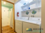 Between the kitchen and bathroom are the Washer and Dryer with detergents. There are four beach towels on the shelf, also.